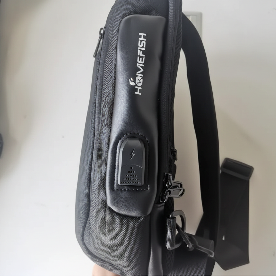 Black GEO sling bag with USB charging port and zippers, shown side view